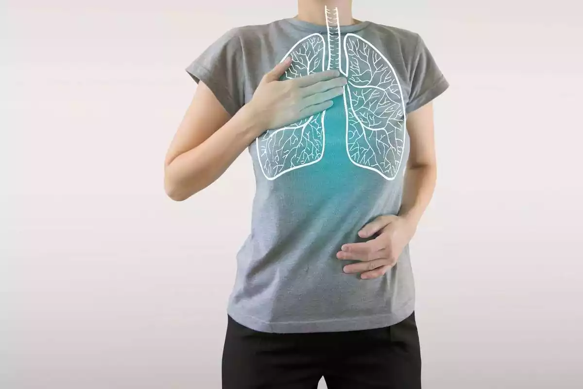 persona se toca el pecho con un dibujo de pulmones