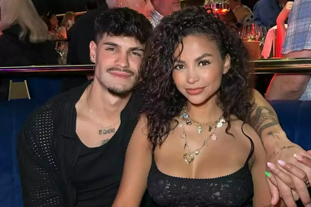 Álvaro y Mayeli sentados en un restaurante elegante sonríe mientras posan juntos para la foto Álvaro y Mayeli sentados en un restaurante elegante sonríe mientras posan juntos para la foto