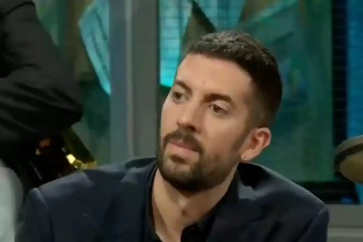 David Broncano con barba corta y cabello oscuro sentado en 'La Revuelta' con expresión seria