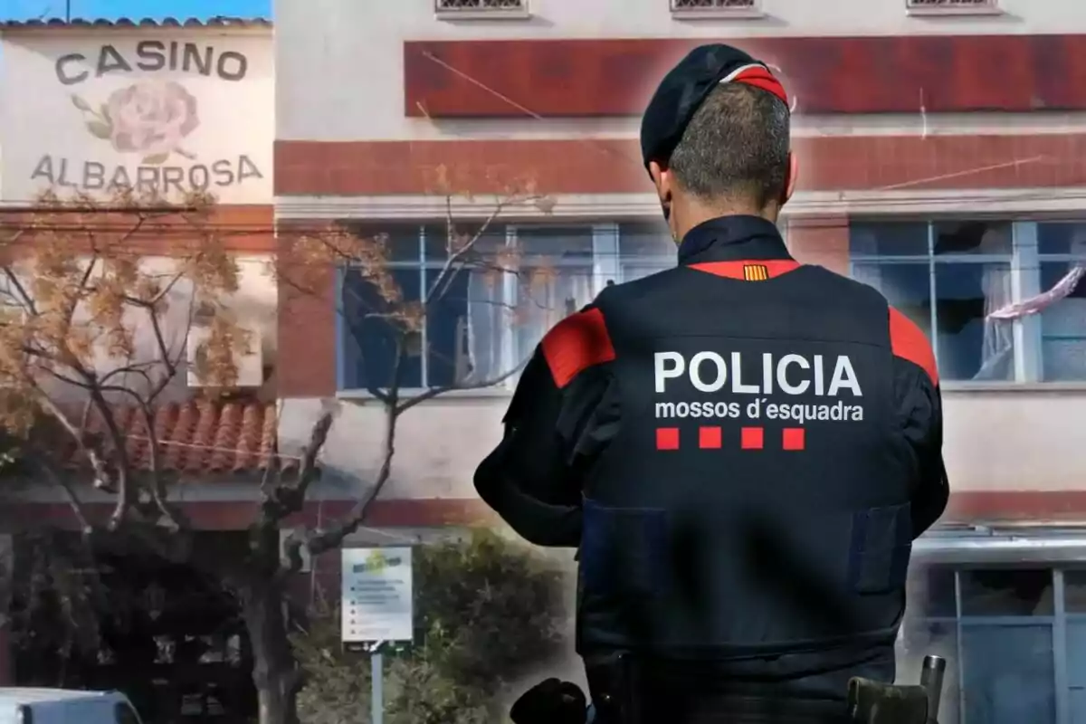Un agente de los Mossos d'Esquadra de espaldas frente a un edificio con el letrero Casino Albarrosa