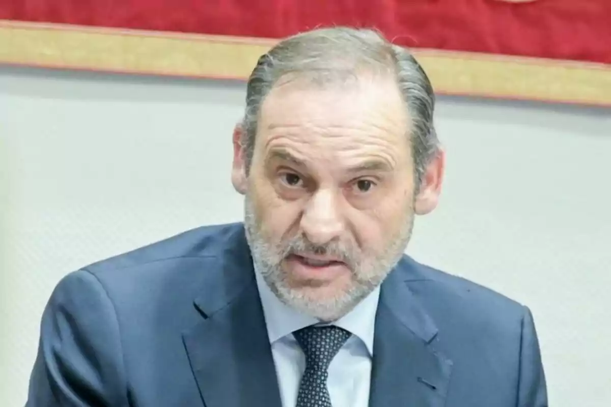 Plano corto de José Luis Ábalos vestido con traje azul y corbata en un entorno formal. Plano corto de José Luis Ábalos vestido con traje azul y corbata en un entorno formal.