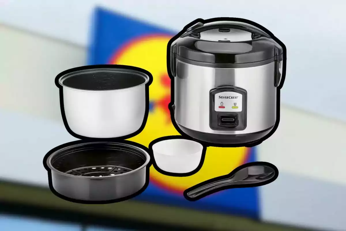 Olla arrocera eléctrica con accesorios sobre un fondo desenfocado de un letrero de supermercado Olla arrocera eléctrica con accesorios sobre un fondo desenfocado de un letrero de supermercado