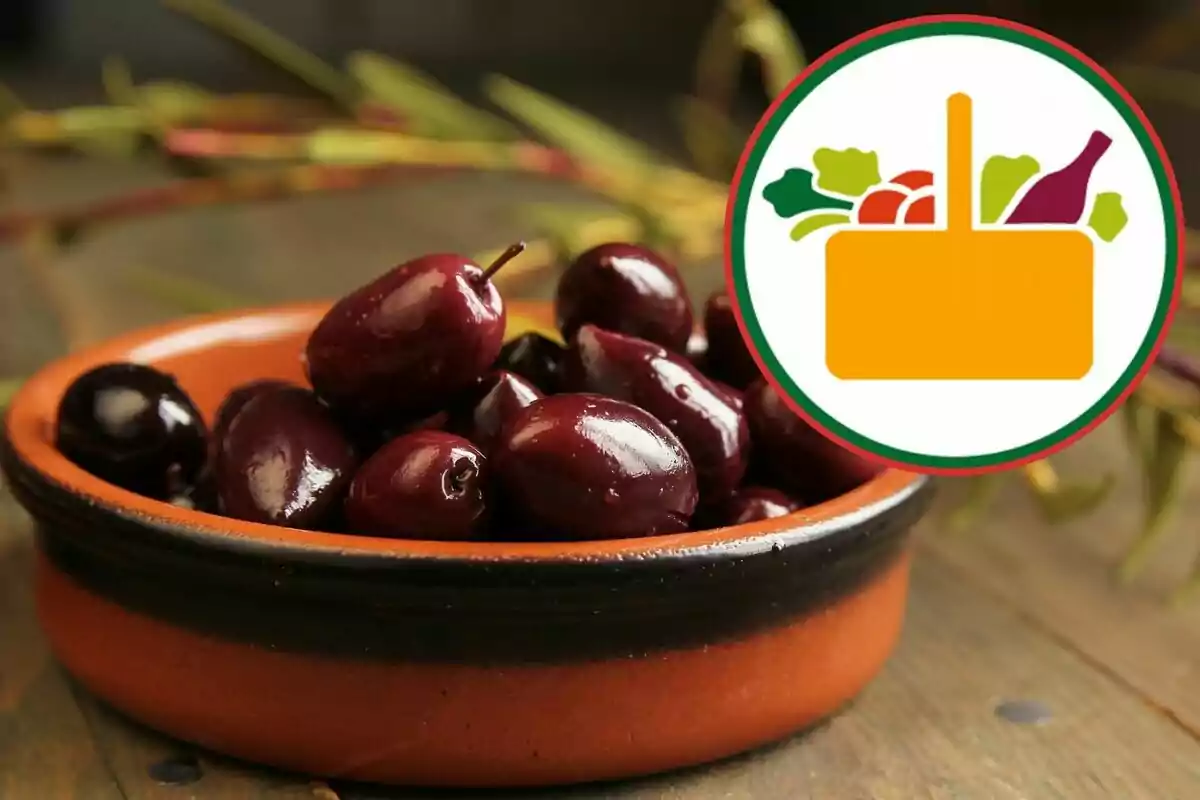 Aceitunas negras en un plato de barro con un logotipo de canasta de alimentos en la esquina superior derecha Aceitunas negras en un plato de barro con un logotipo de canasta de alimentos en la esquina superior derecha