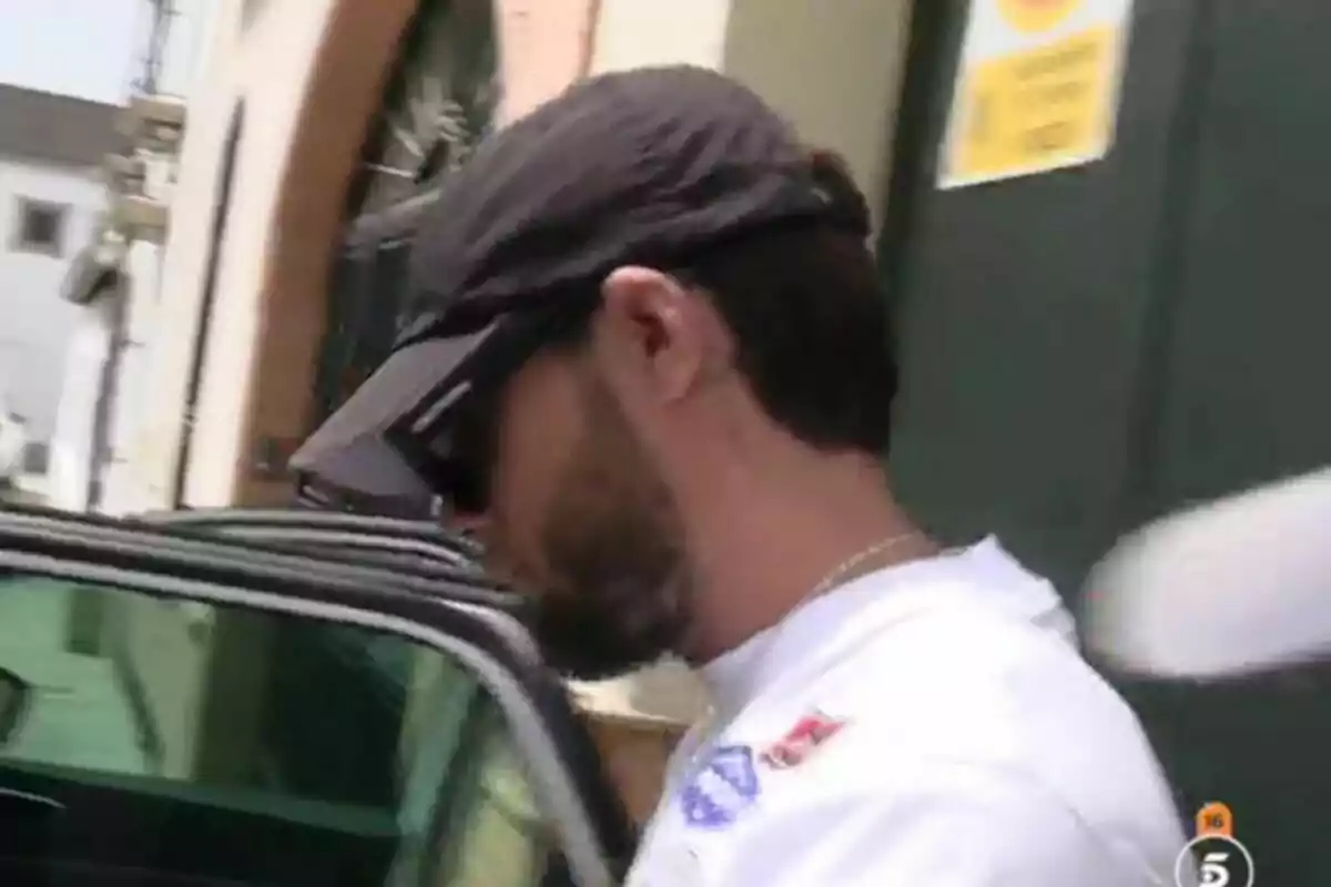 Montoya con gorra y gafas oscuras entrando a un coche en una calle urbana Montoya con gorra y gafas oscuras entrando a un coche en una calle urbana