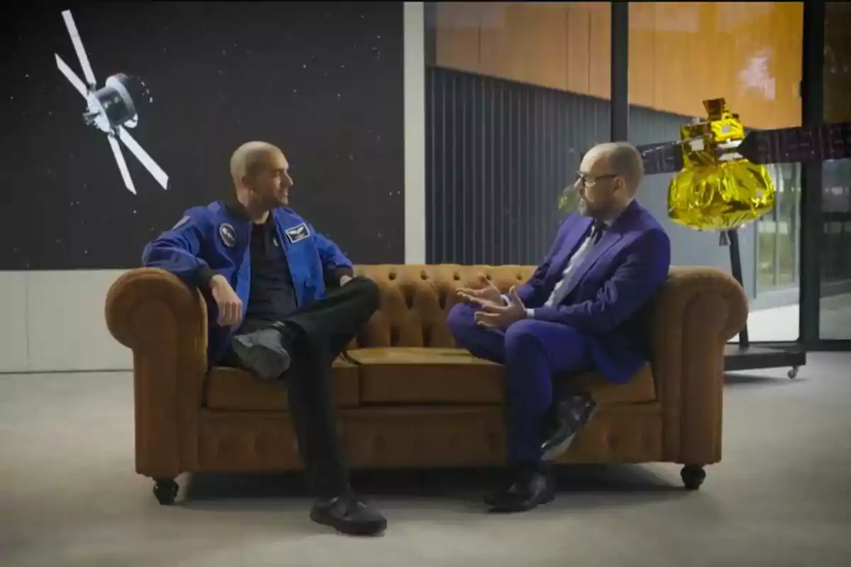 Risto Mejide y Pablo Álvarez conversan sentados en un sofá marrón, uno lleva un traje azul de astronauta y el otro viste un traje formal, al fondo se observan imágenes de satélites y una nave espacial en 'Viajando con Chester'. Risto Mejide y Pablo Álvarez conversan sentados en un sofá marrón, uno lleva un traje azul de astronauta y el otro viste un traje formal, al fondo se observan imágenes de satélites y una nave espacial en 'Viajando con Chester'.