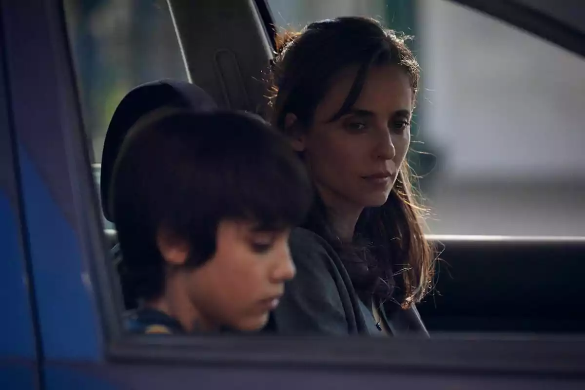 Leticia Dolera y un niño sentados dentro de un auto con expresiones serias y pensativas en la serie Pubertad