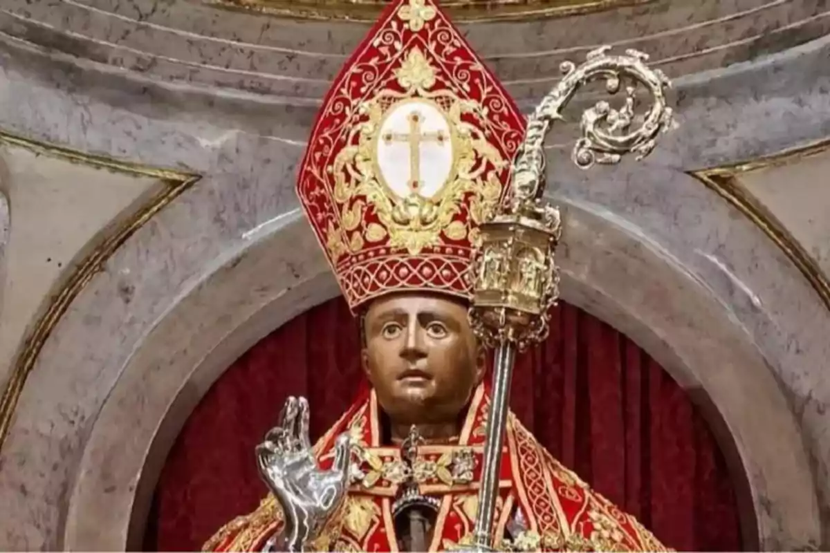 Estatua religiosa de un obispo con vestimenta roja y dorada, mitra decorada y báculo en la mano Estatua religiosa de un obispo con vestimenta roja y dorada, mitra decorada y báculo en la mano