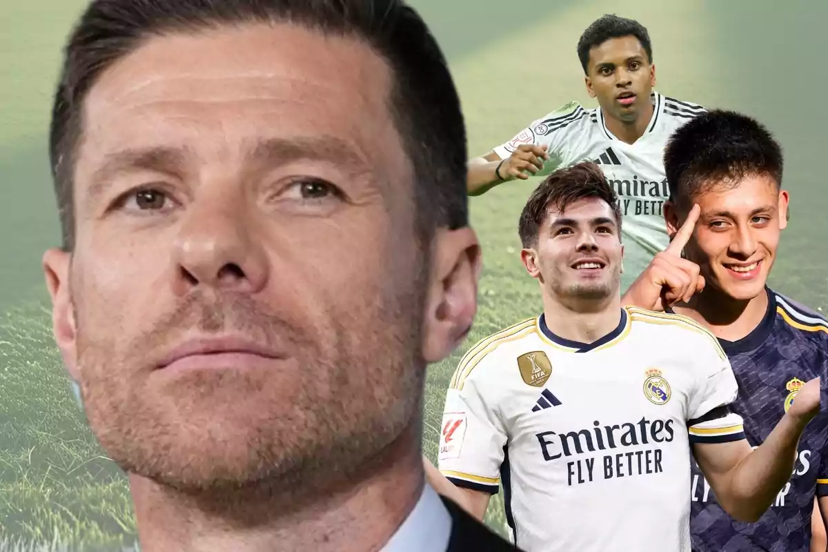 Un hombre de rostro serio en primer plano con tres futbolistas del Real Madrid al fondo sobre un campo de fútbol desenfocado