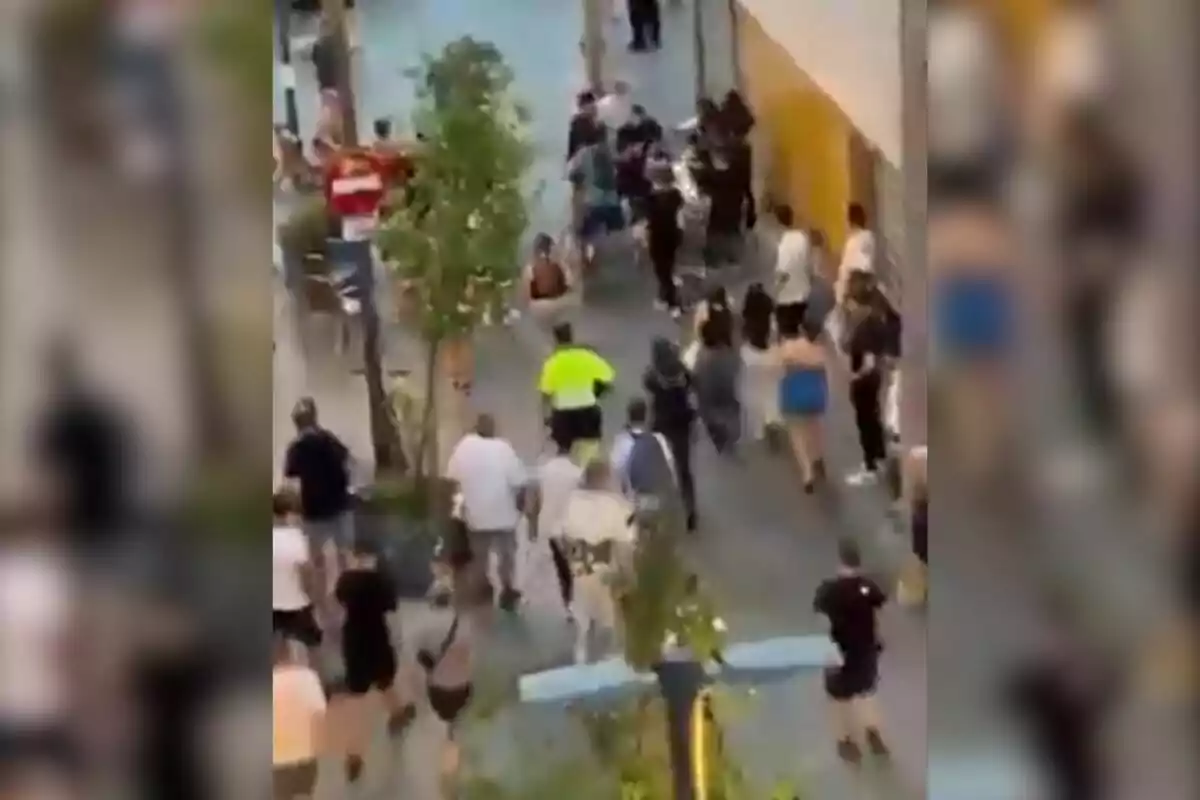 Varias personas corren por una calle peatonal en lo que parece ser una situación de caos o emergencia