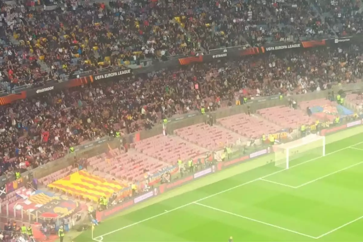 Estadio de fútbol con gradas parcialmente vacías y aficionados en las tribunas durante un partido de la UEFA Europa League Estadio de fútbol con gradas parcialmente vacías y aficionados en las tribunas durante un partido de la UEFA Europa League