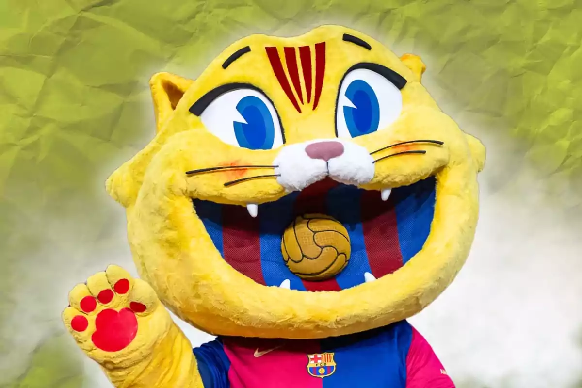 Gato amarillo disfrazado como mascota del FC Barcelona con camiseta azulgrana y fondo verde desenfocado