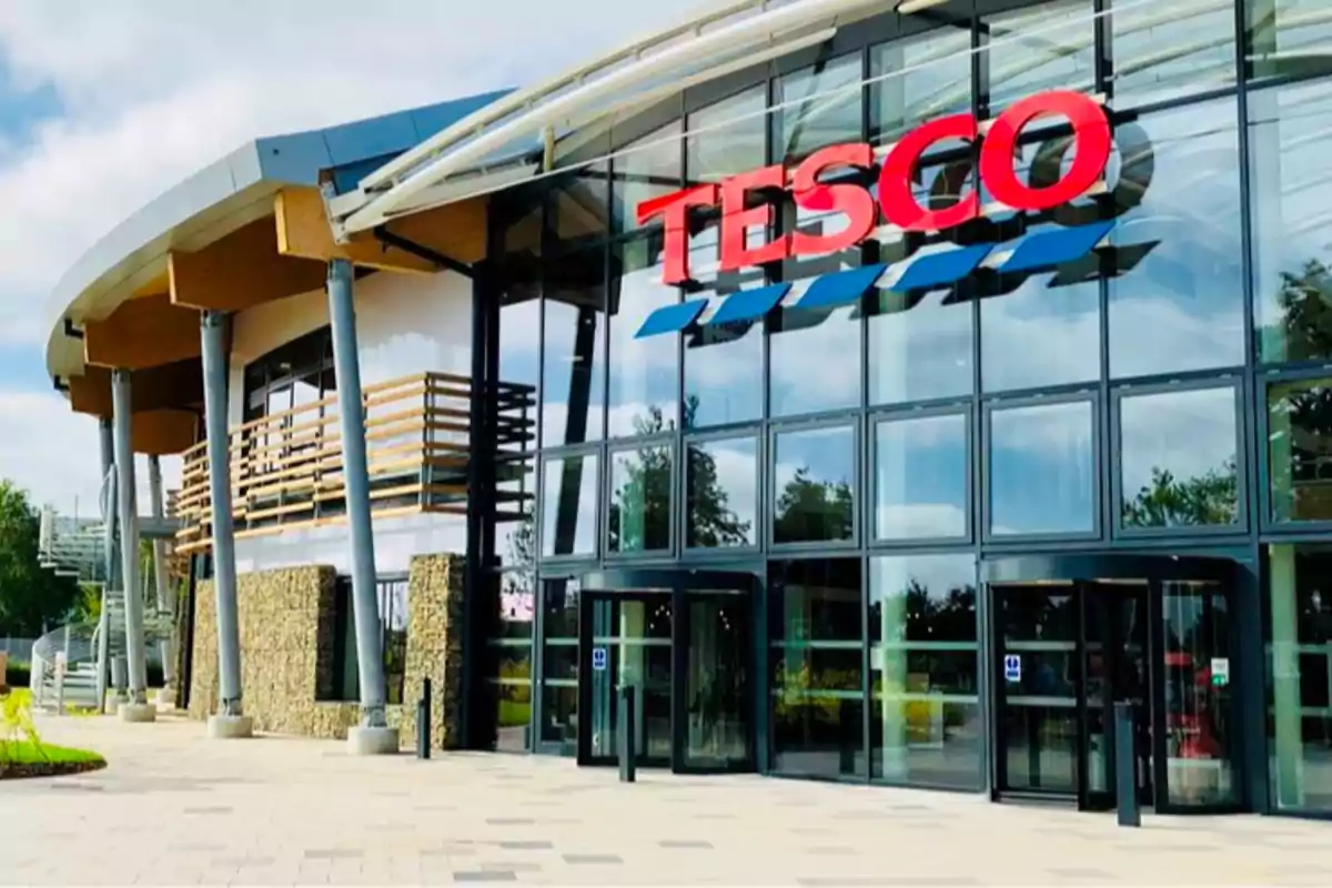 Fachada moderna de una tienda Tesco con grandes ventanales y entrada principal visible