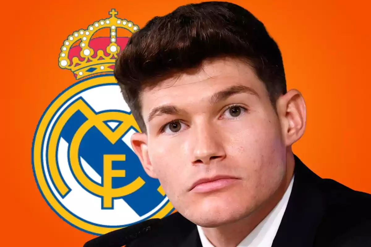 Joven con cabello corto y expresión seria frente al escudo del Real Madrid sobre un fondo naranja