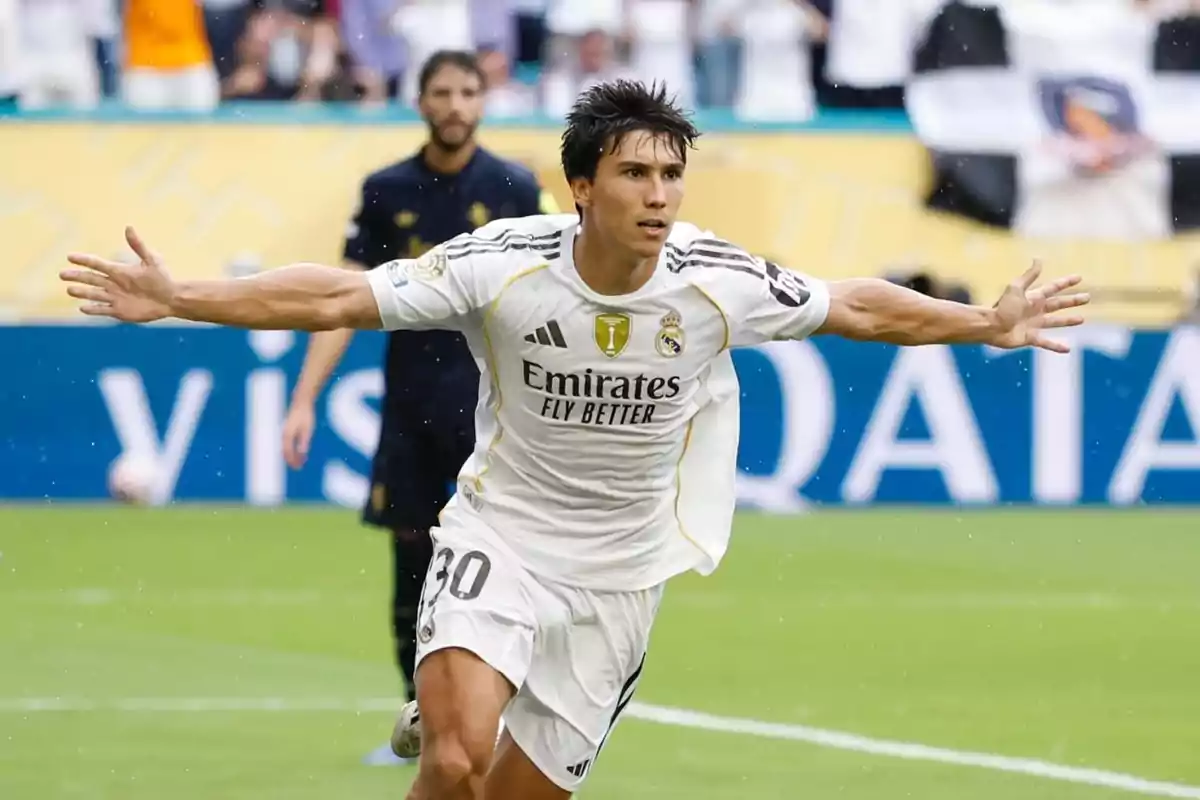 Futbolista del Real Madrid celebrando un gol con los brazos extendidos en un estadio durante un partido Futbolista del Real Madrid celebrando un gol con los brazos extendidos en un estadio durante un partido