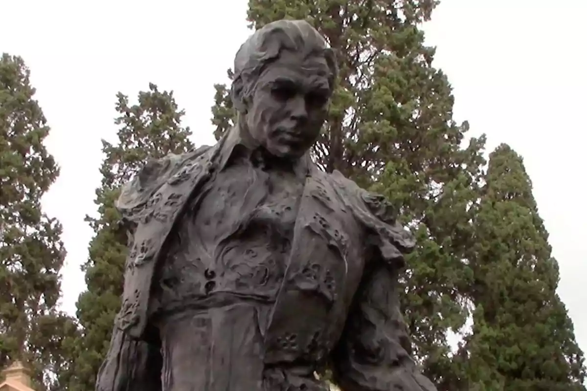 Escultura de un torero con árboles altos al fondo Escultura de un torero con árboles altos al fondo