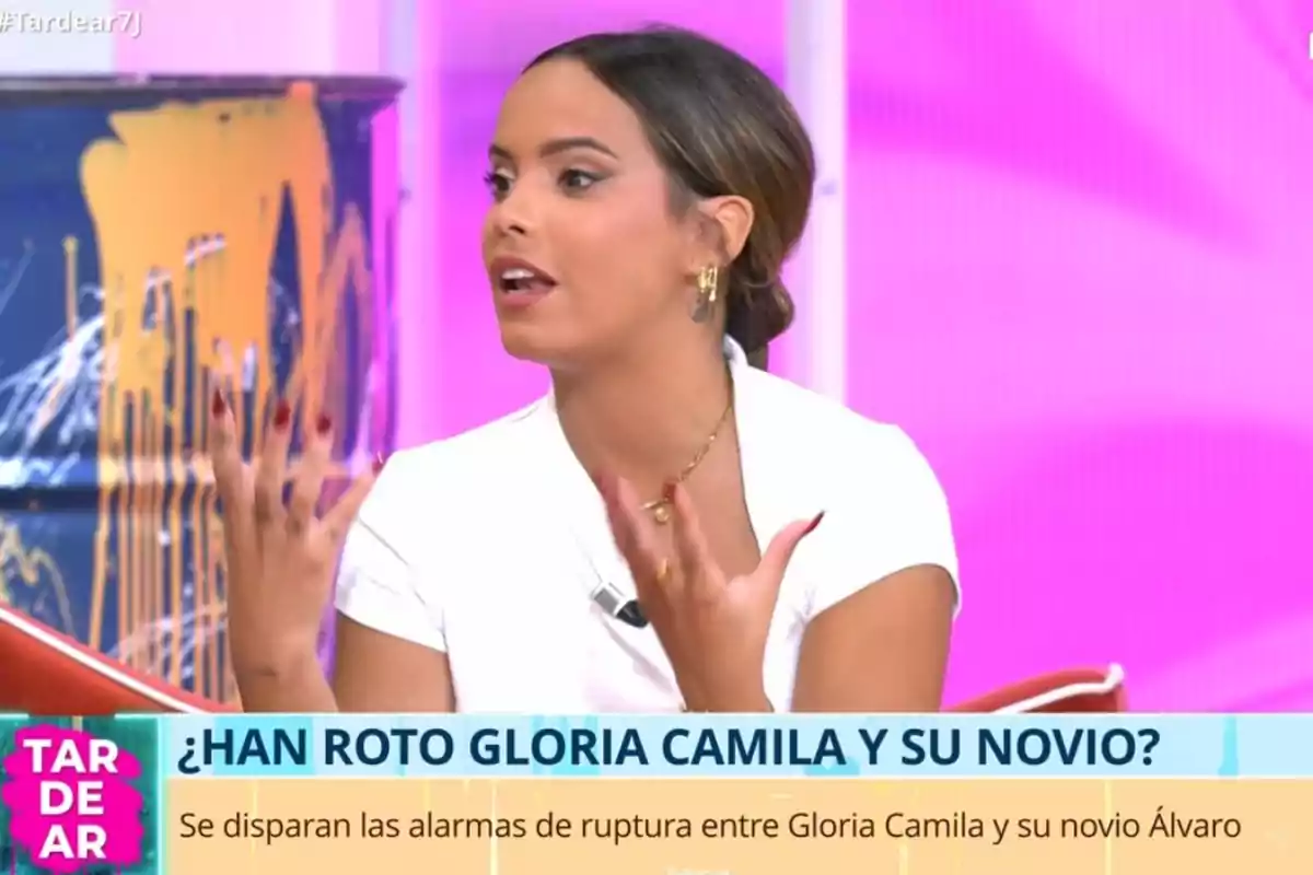 Gloria Camila hablando en un programa de televisión con fondo rosa y un rótulo que pregunta sobre la posible ruptura de Gloria Camila y su novio Gloria Camila hablando en un programa de televisión con fondo rosa y un rótulo que pregunta sobre la posible ruptura de Gloria Camila y su novio