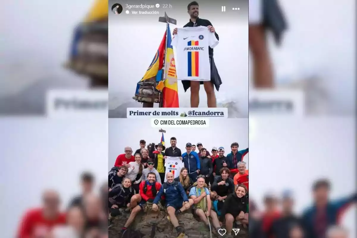 Un hombre sostiene una camiseta de fútbol junto a una bandera en la cima de una montaña rodeado de un grupo de personas sonrientes Un hombre sostiene una camiseta de fútbol junto a una bandera en la cima de una montaña rodeado de un grupo de personas sonrientes