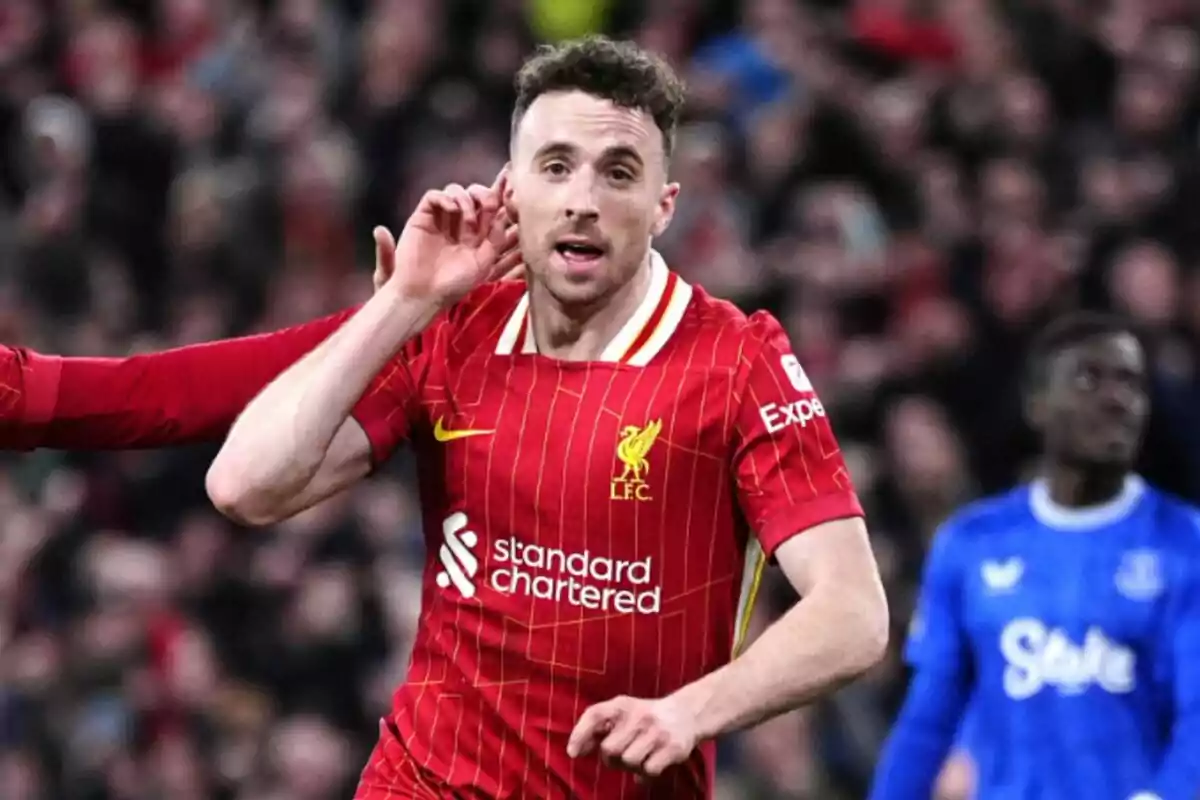 Futbolista del Liverpool celebrando un gol en un partido con la mano en la oreja y fondo de estadio lleno Futbolista del Liverpool celebrando un gol en un partido con la mano en la oreja y fondo de estadio lleno
