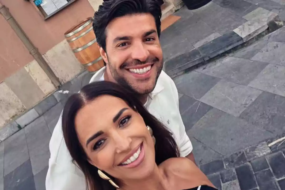 Paula Echevarría y Miguel Torres sonrientes tomándose una selfie al aire libre en una calle de piedra Paula Echevarría y Miguel Torres sonrientes tomándose una selfie al aire libre en una calle de piedra