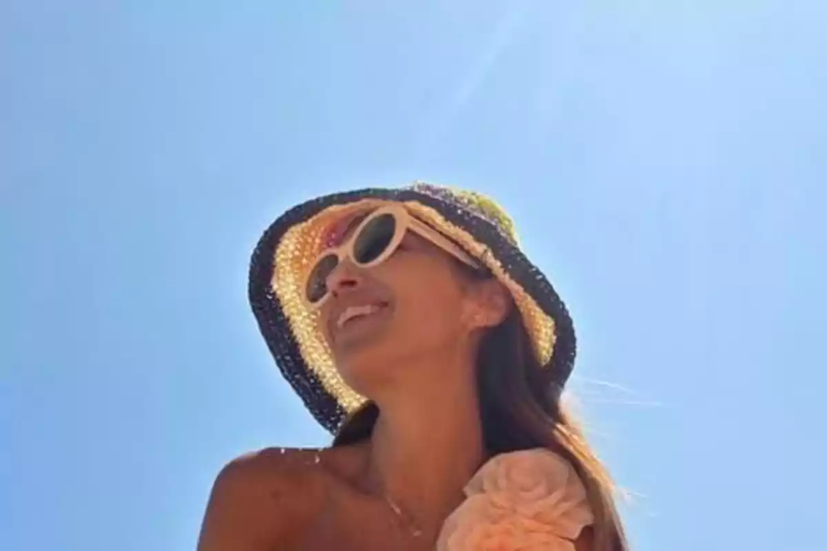 Paula Echevarría sonriente con gafas de sol y sombrero de colores bajo un cielo despejado Paula Echevarría sonriente con gafas de sol y sombrero de colores bajo un cielo despejado
