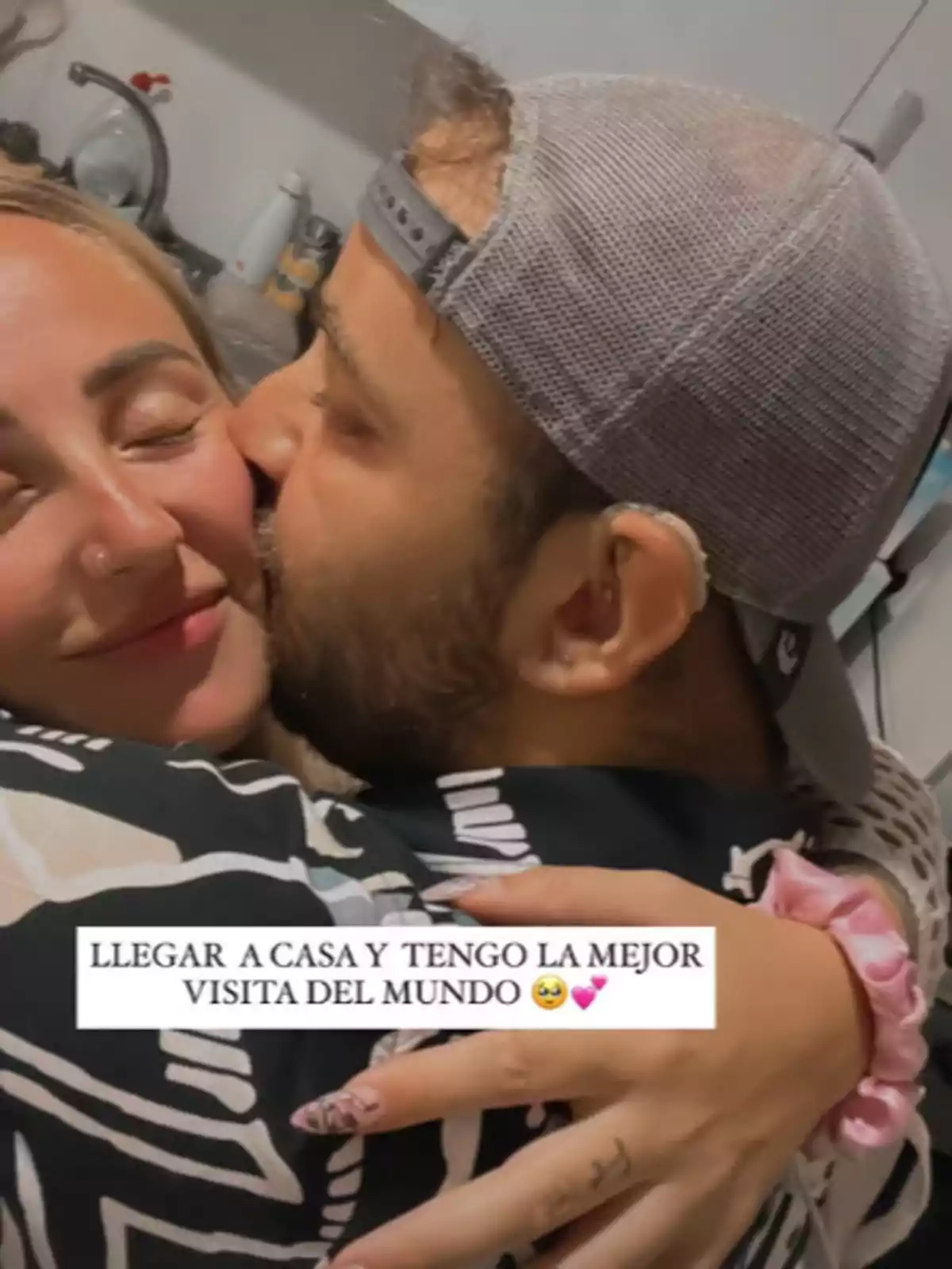 Rocío Flores y David Flores Carrasco se abrazan con alegría en una cocina, mientras el hombre besa la mejilla de la mujer y ambos sonríen con los ojos cerrados, transmitiendo felicidad y cariño. Rocío Flores y David Flores Carrasco se abrazan con alegría en una cocina, mientras el hombre besa la mejilla de la mujer y ambos sonríen con los ojos cerrados, transmitiendo felicidad y cariño.