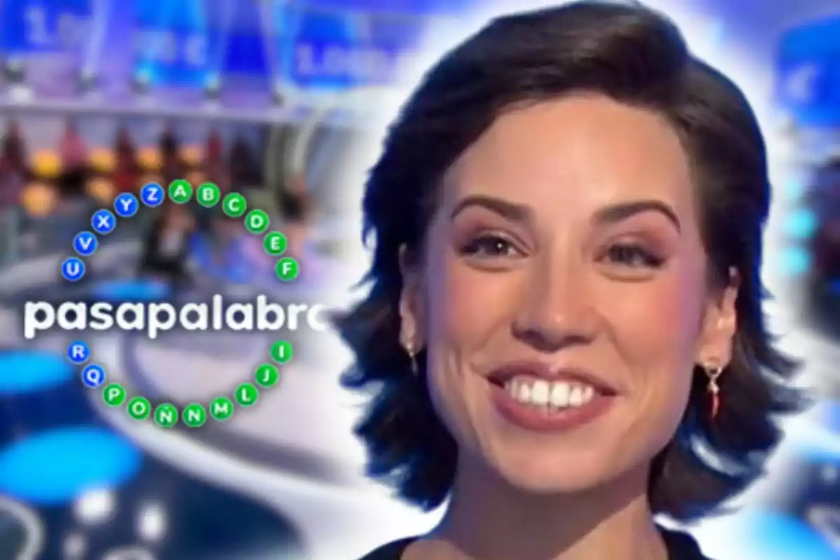 Rosa Rodríguez sonriente en primer plano con el logo del programa 'Pasapalabra' de fondo en un plató de televisión.