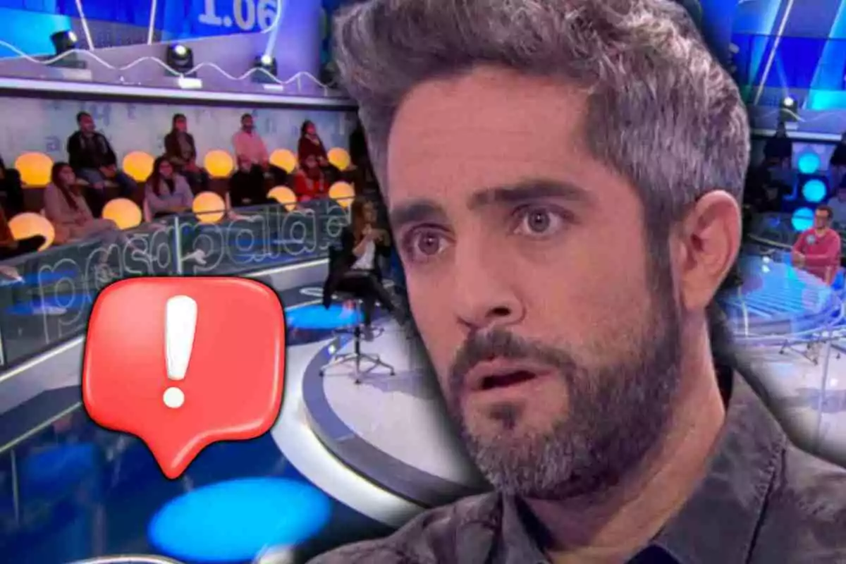 Roberto Leal con expresión de sorpresa en 'Pasapalabra' con público y un ícono de advertencia rojo en primer plano
