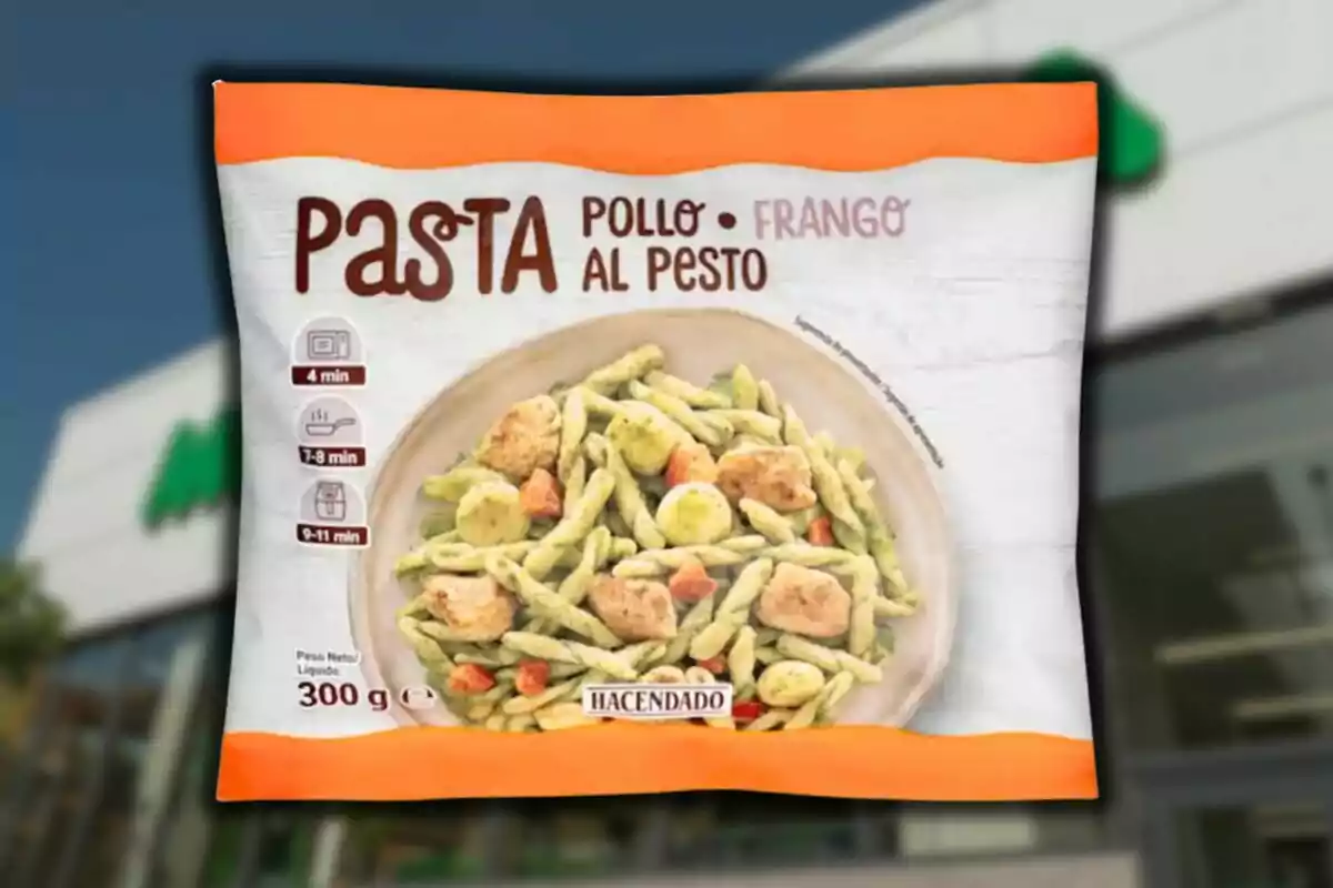 Envase de pasta al pesto con pollo de la marca Hacendado sobre un fondo desenfocado de supermercado Envase de pasta al pesto con pollo de la marca Hacendado sobre un fondo desenfocado de supermercado