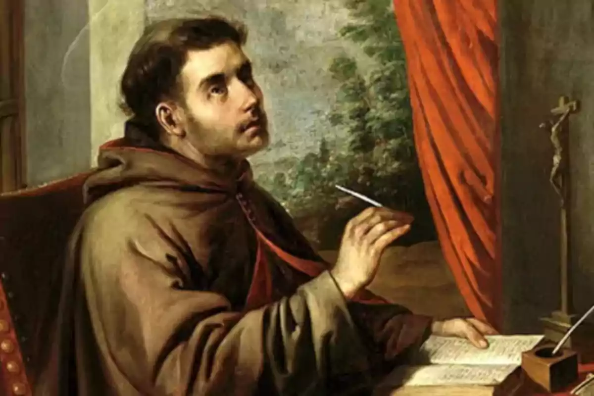 Un monje con hábito marrón está sentado escribiendo en un libro mientras mira hacia arriba, junto a una ventana con cortina roja y un crucifijo sobre la mesa. Un monje con hábito marrón está sentado escribiendo en un libro mientras mira hacia arriba, junto a una ventana con cortina roja y un crucifijo sobre la mesa.