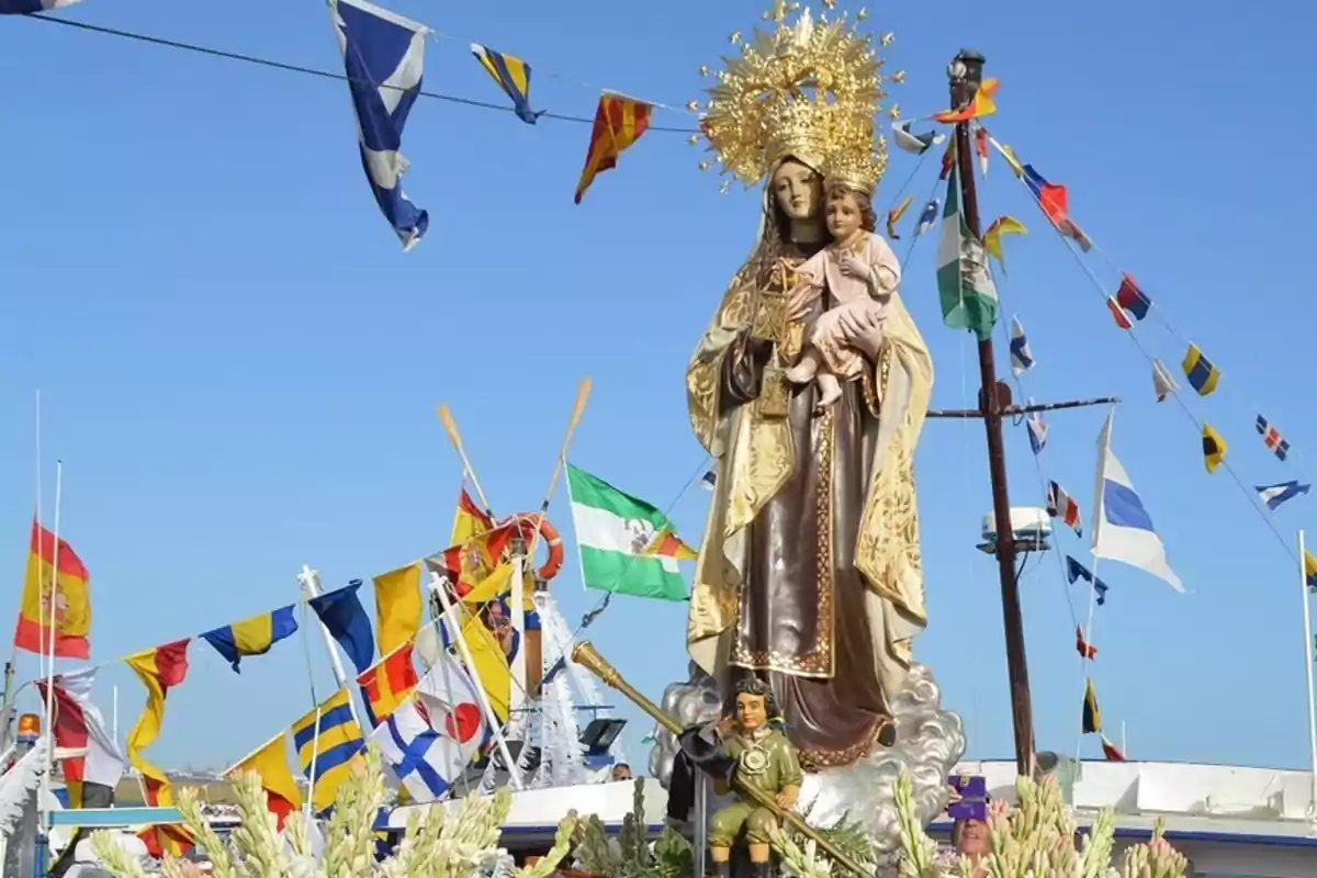 Imagen de una procesión marítima con una estatua de la Virgen del Carmen rodeada de banderas de colores y flores bajo un cielo despejado Imagen de una procesión marítima con una estatua de la Virgen del Carmen rodeada de banderas de colores y flores bajo un cielo despejado