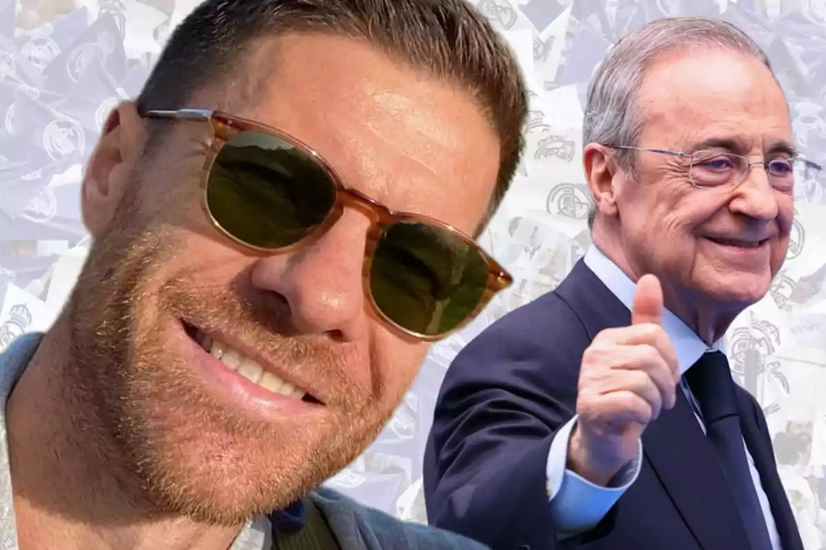 Dos hombres sonríen, uno lleva gafas de sol y el otro viste traje y hace un gesto de pulgar arriba, con un fondo de banderas blancas.