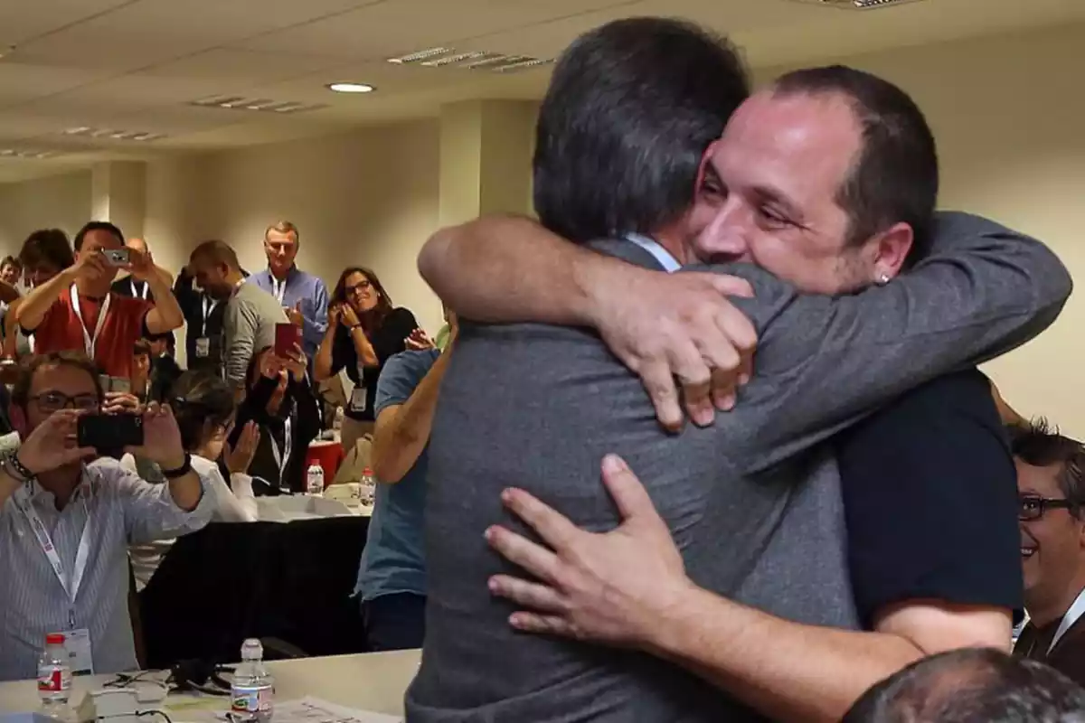 Abrazo entre Artur Mas y David Fernández delante de los medios en 2014