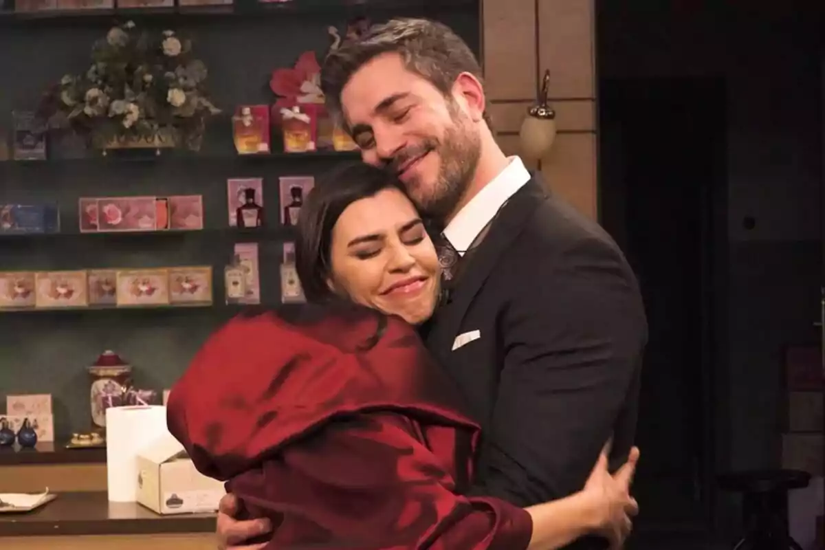 Roser Tapias y Dani Tatay abrazándose con expresión de felicidad en Sueños de Libertad en una tienda decorada con flores y cajas de productos en el fondo Roser Tapias y Dani Tatay abrazándose con expresión de felicidad en Sueños de Libertad en una tienda decorada con flores y cajas de productos en el fondo