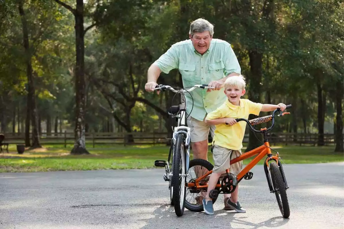 Un niño con un hombre mayor felices con sus bicicletas
