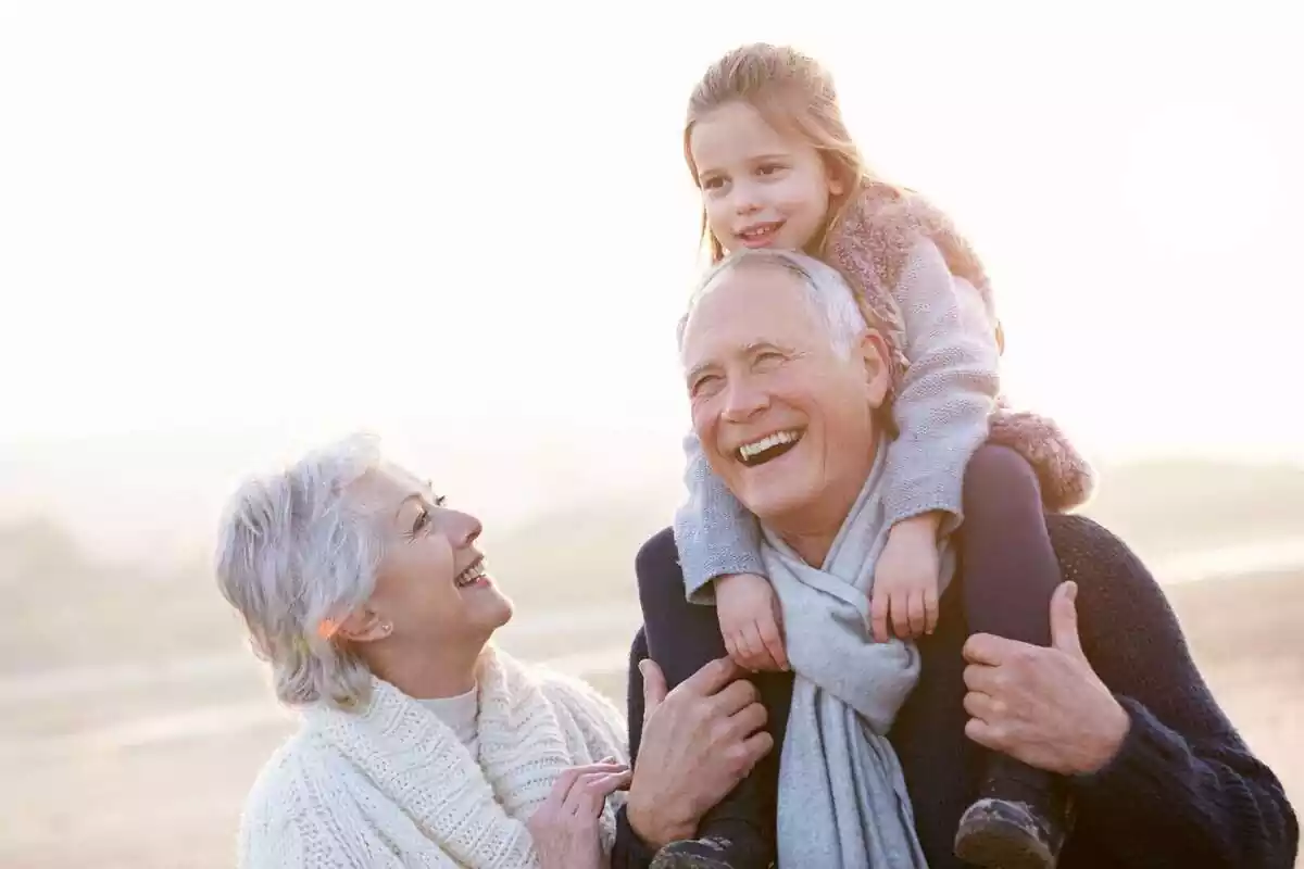 Smiling grandparents and granddaughter