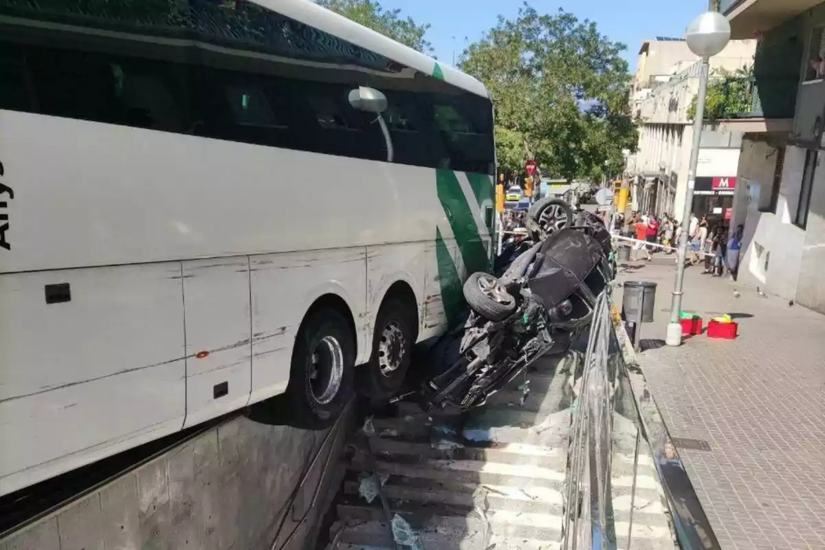 Un autobús y un coche accidentado en unas escaleras en una zona urbana.