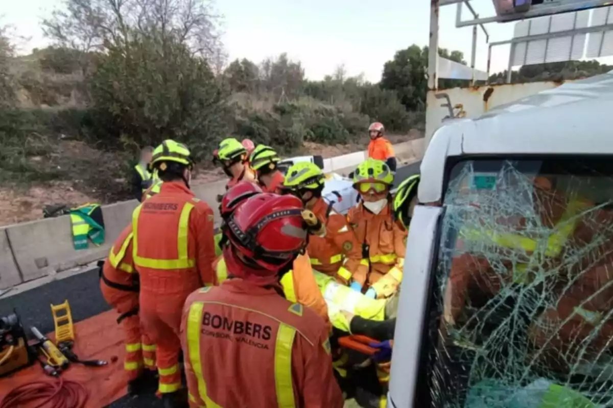 Bomberos realizando un rescate en un accidente de tráfico con un vehículo dañado y un parabrisas roto.