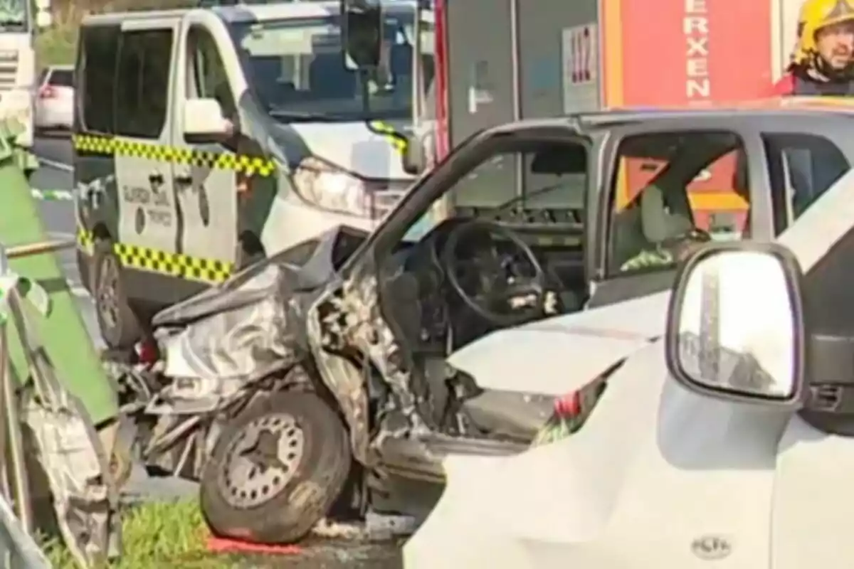 Un vehículo con daños significativos en la parte delantera tras un accidente de tráfico con un coche de la Guardia Civil en el fondo.