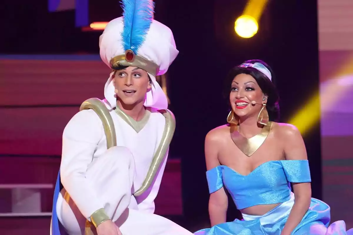 Raoul Vázquez y Ana Guerra disfrazadas de Aladdín y Jazmín sonríen en un escenario iluminado de Tu Cara Me Suena Raoul Vázquez y Ana Guerra disfrazadas de Aladdín y Jazmín sonríen en un escenario iluminado de Tu Cara Me Suena
