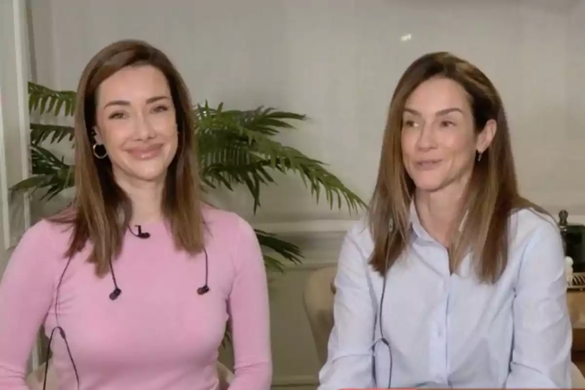 Adara Molinero y Elena Rodríguez sonríen mientras están sentadas en un ambiente interior con plantas al fondo.