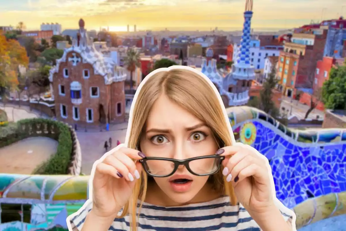 Una mujer con expresión de sorpresa sostiene sus gafas frente a un fondo de un parque colorido y arquitectónicamente distintivo.