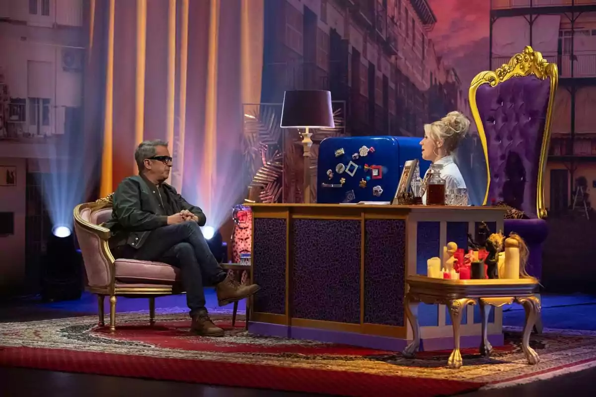 Andreu Buenafuente y Henar Álvarez conversan en 'Al cielo con ella' decorado con muebles elegantes y luces de fondo. Andreu Buenafuente y Henar Álvarez conversan en 'Al cielo con ella' decorado con muebles elegantes y luces de fondo.