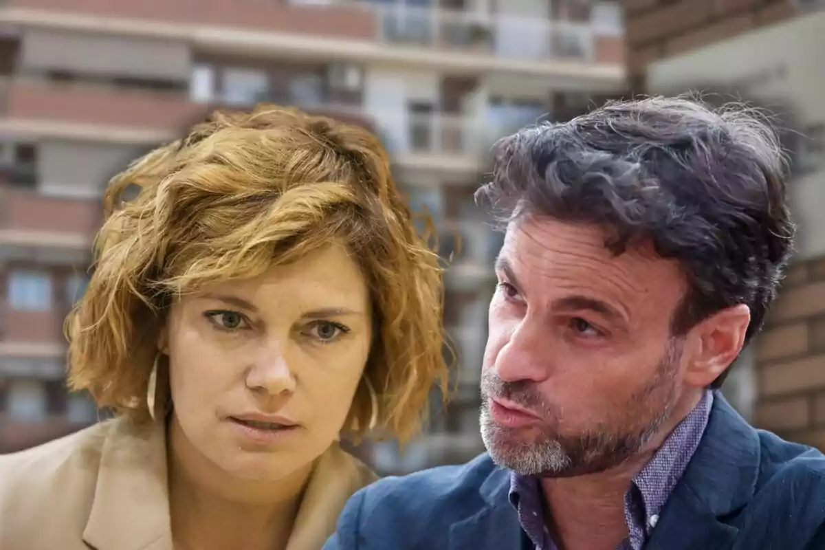 Dos personas adultas conversando con expresiones serias frente a un edificio de apartamentos desenfocado.