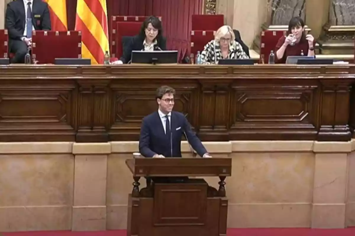 Alberto Tarradas en el atril del Parlament de Catalunya y en la parte superior los miembros de la Mesa del Parlament Anna Erra y Aurora Madaula