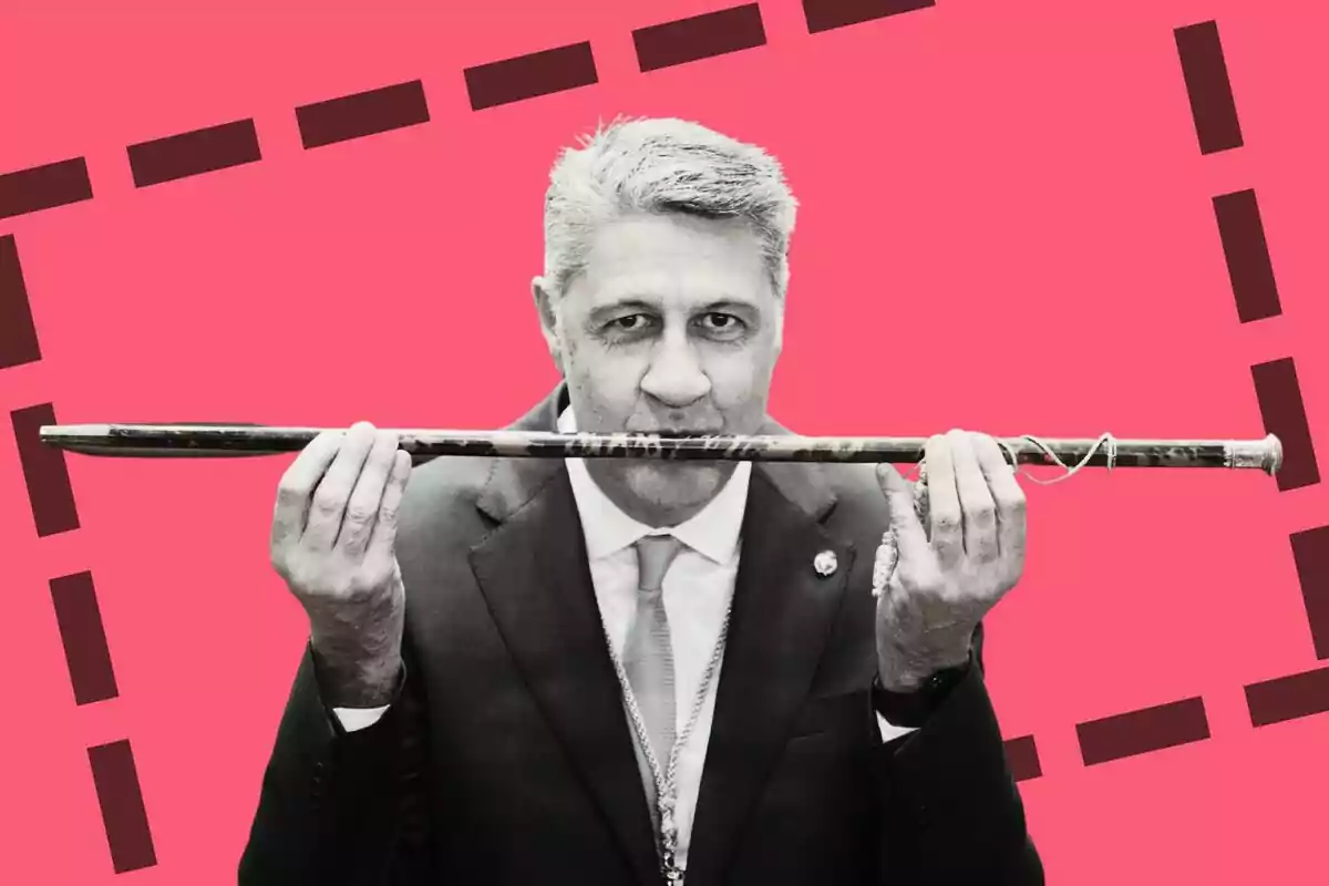 Plano medio de Xavier García Albiol en blanco y negro besando la vara de alcalde y un fondo de color rojo