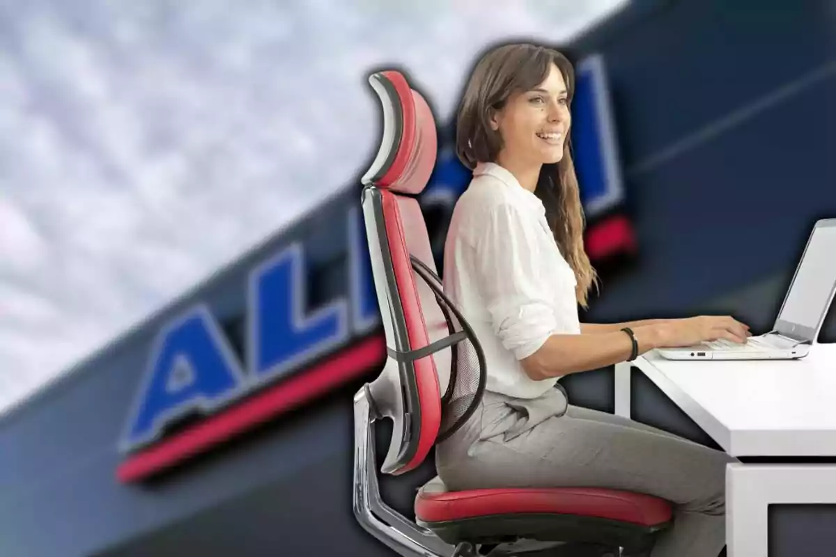 Una mujer sentada en una silla ergonómica roja trabajando en una computadora portátil con un fondo borroso de un edificio con un letrero. Una mujer sentada en una silla ergonómica roja trabajando en una computadora portátil con un fondo borroso de un edificio con un letrero.