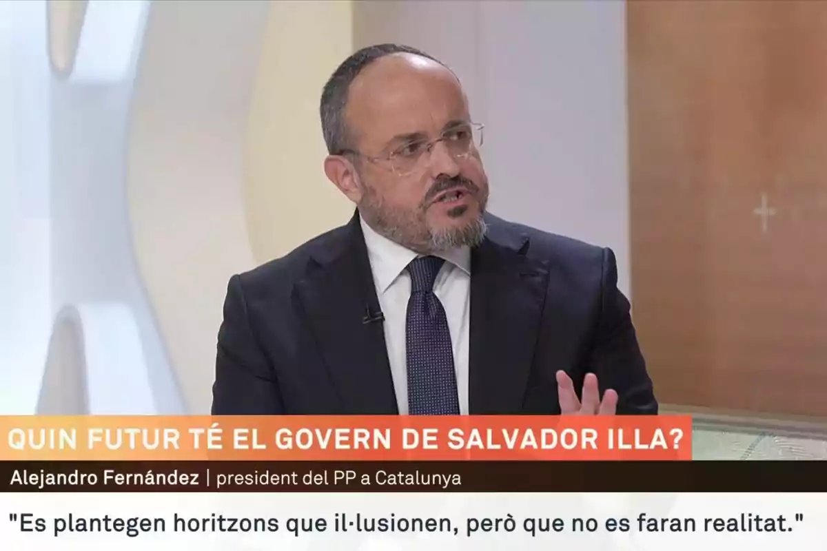 Un hombre con barba y gafas, vestido con traje oscuro y corbata, está hablando en un programa de televisión. En la parte inferior de la imagen hay texto en catalán sobre el futuro del gobierno de Salvador Illa.