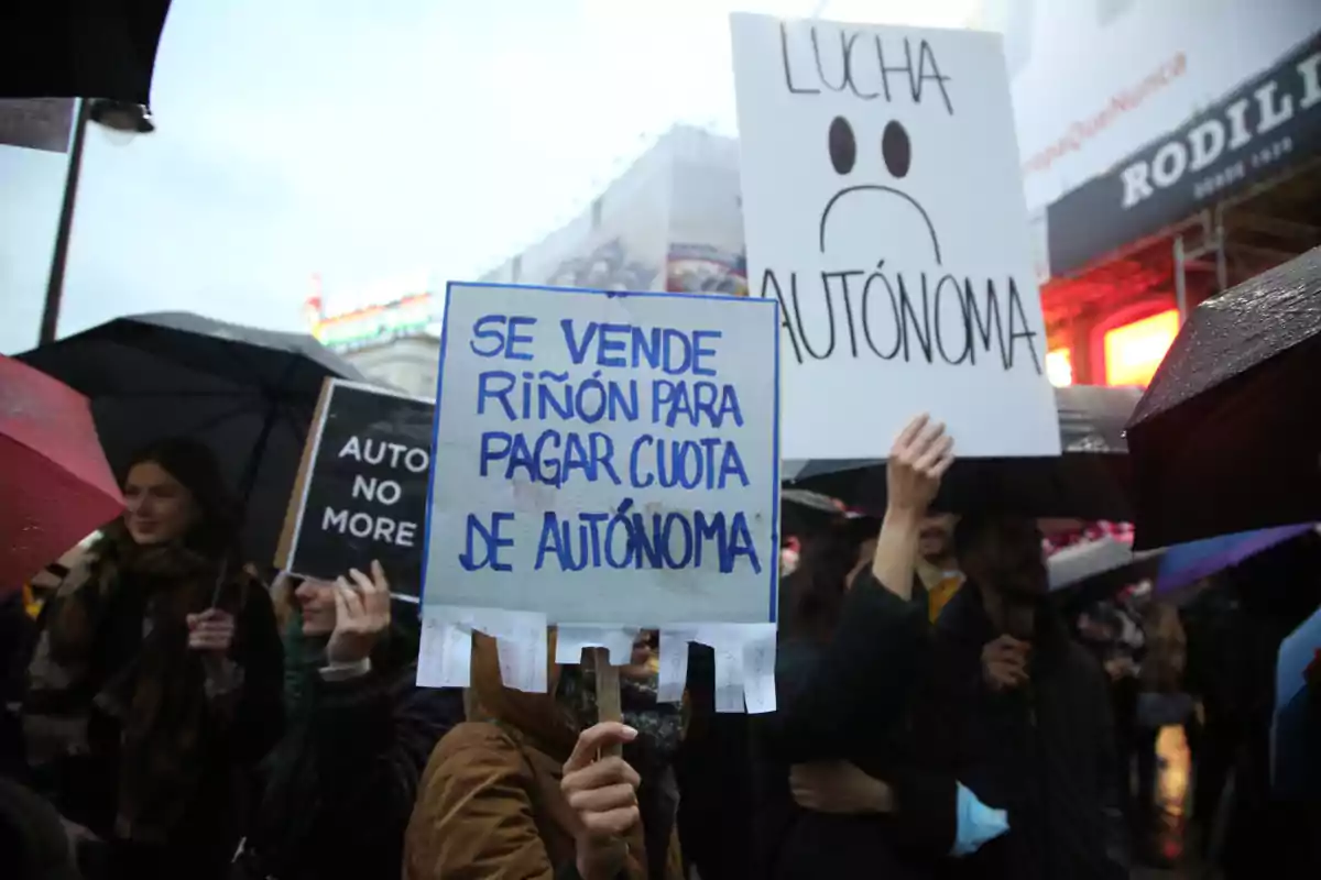 Personas manifestándose bajo la lluvia con pancartas que expresan descontento por la situación de los trabajadores autónomos
