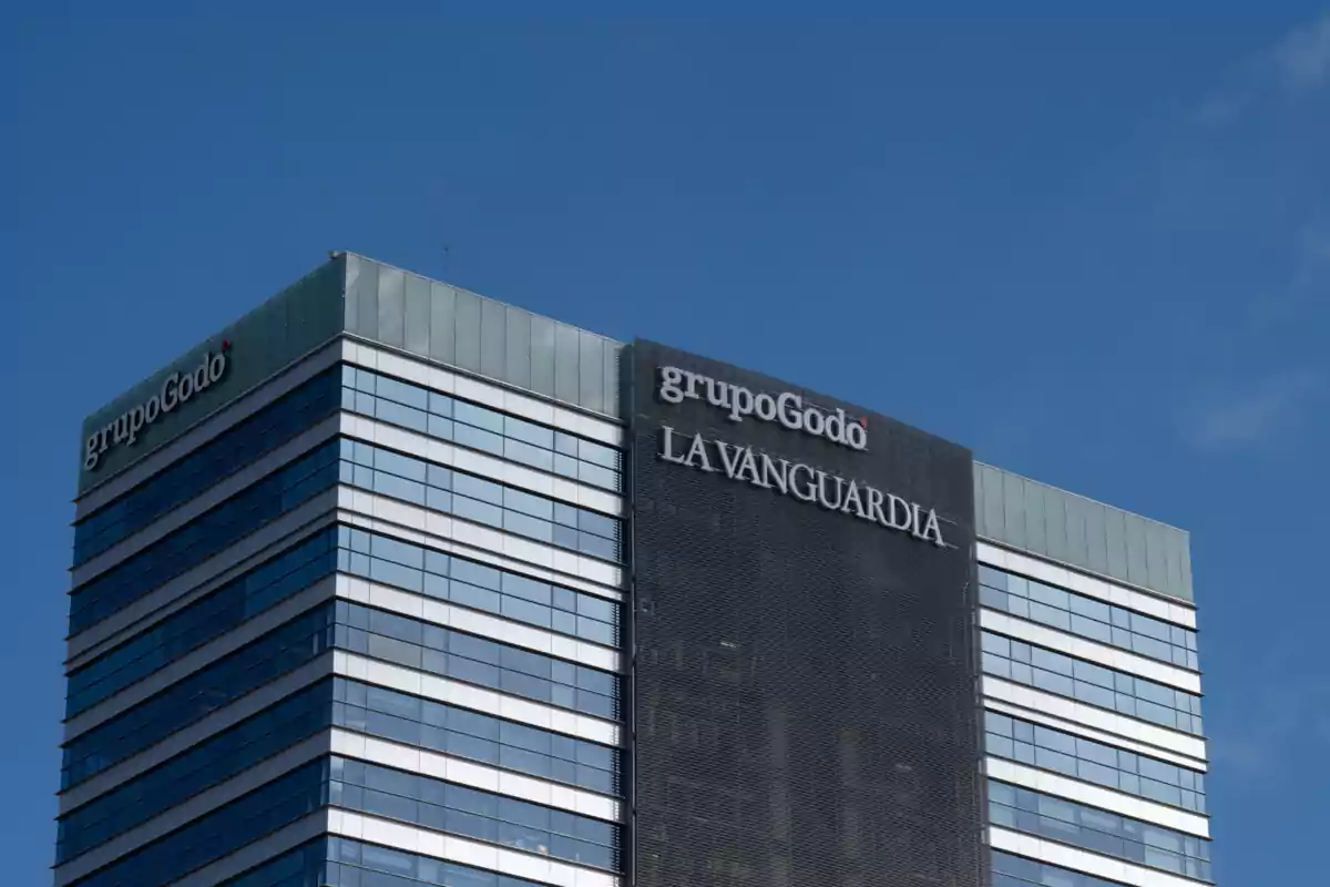 Edificio de oficinas con los logotipos de Grupo Godó y La Vanguardia en la fachada.