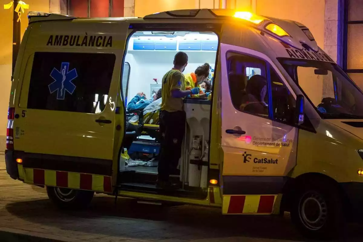 Plano general de una ambulancia de noche atendiendo a una persona herida en Girona